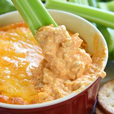 a bowl filled with dip and celery sticks