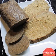 two slices of bread on a white plate next to an uncooked piece of bread