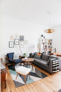 a living room filled with furniture and decor on top of a hard wood floored floor