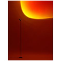 a floor lamp in front of a red wall