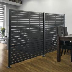 a dining room table and chairs are in front of a sliding door that is made out of metal slats