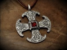 The Canterbury cross, an 8th century Anglo-Saxon brooch, reproduced here as a pendant in sterling silver and set with a 6mm square garnet stone. Hand cast, detailed and polished to a silver shine. Measures 4.5cm × 4cm and includes a 1 meter leather cord. Mjolnir Pendant, Coil Ring, Twisted Bracelet, Bronze Ring, Anglo Saxon, Garnet Stone, Finger Rings, Hand Cast, Cross Pendant Necklace