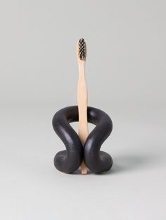 a wooden toothbrush sitting on top of a black and white object with one tooth brush in it's mouth