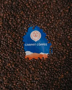 coffee beans are scattered around a blue sign that reads carabat coffee on it's side