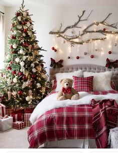 a teddy bear sitting on a bed in front of a christmas tree with lights and presents