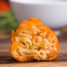 a piece of macaroni and cheese sitting on top of a wooden table