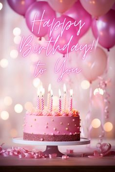 a birthday cake with pink frosting and lit candles