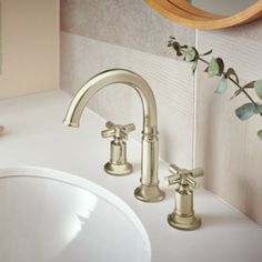 a white sink sitting under a mirror next to a faucet in a bathroom