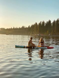 two people are sitting on surfboards in the water