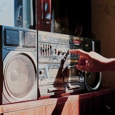 a person touching the radio on top of a table