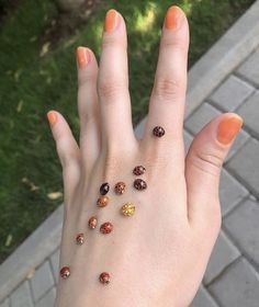 a woman's hand with many different colored stones on it