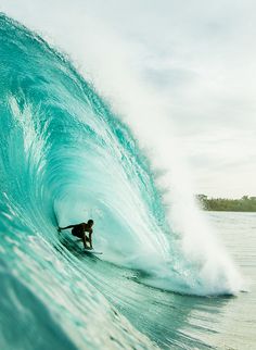 a man riding a wave on top of a surfboard