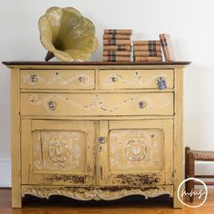 an old yellow dresser with books on top