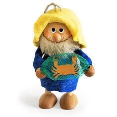 a small doll with a yellow hat and blue shirt holding a green bag in it's hands