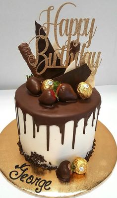 a birthday cake decorated with chocolate, strawberries and an inscription happy birthday on top