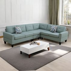 a living room with a sectional couch, coffee table and rug in front of it