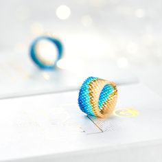 a blue and gold ring sitting on top of a piece of paper