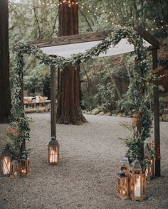 an outdoor ceremony with candles and greenery