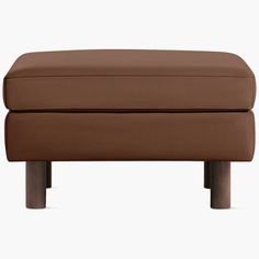 a brown ottoman sitting on top of a wooden table