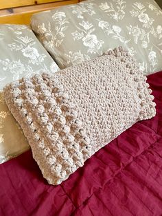 a crocheted pillow sitting on top of a bed