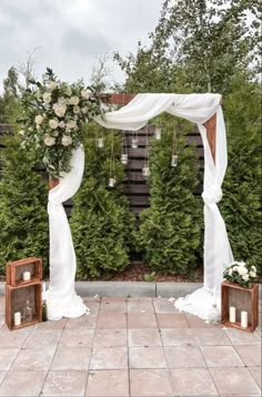 an outdoor ceremony with white flowers and greenery