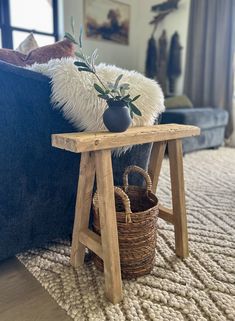 a small wooden table sitting on top of a rug next to a blue couch in a living room