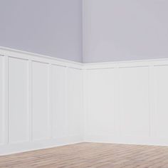 empty room with wood floor and white paneling on the walls, in front of a gray painted wall