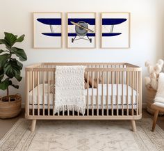 a baby's room with two paintings on the wall and a crib in the foreground