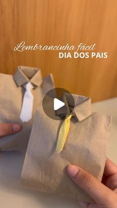 two hands are holding some paper bags with ties on them and one has a yellow tie