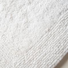 a close up view of a white rug on the floor with no one in it