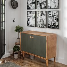 a wooden cabinet sitting next to a wall with pictures on it