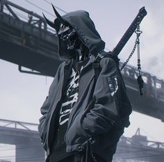 a man wearing a hoodie and holding a baseball bat in front of a bridge