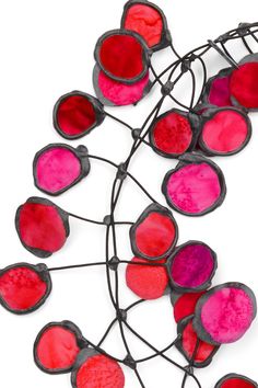 a bunch of red and pink lights hanging from a wire