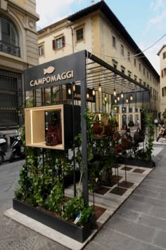 a building with plants growing out of it's sides on the side of the street