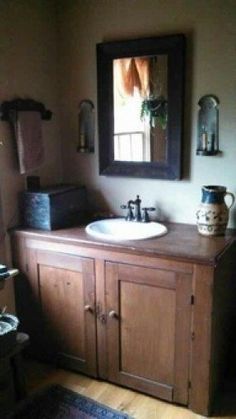 a bathroom with a sink, mirror and rugs on the floor in front of it