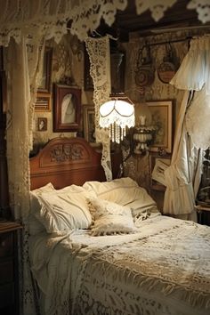 an old fashioned bedroom with white bedding and lace drapes hanging from the ceiling