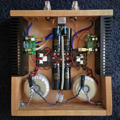 an electronic device with many wires and components in it's wooden case on the floor