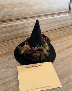 a black witches hat sitting on top of a wooden table next to a notepad