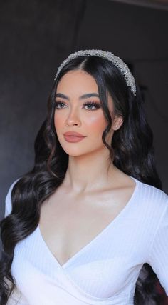 a woman with long hair wearing a white dress and headband, posing for the camera