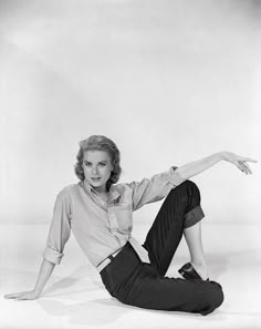 black and white photograph of a woman sitting on the ground with her arms outstretched in front of her body