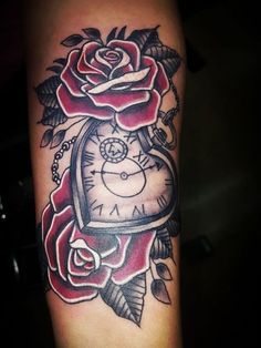 a tattoo with a clock and roses on it