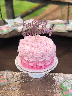 a birthday cake with pink frosting and a happy birthday sign on top that says happy birthday