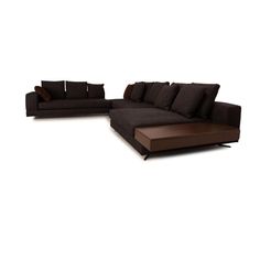 a brown couch with pillows on it and a chair in the middle, sitting next to each other