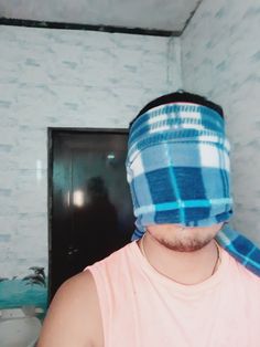 a man with a bandana wrapped around his head standing in front of a sink