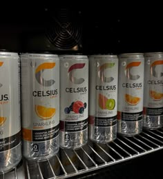 several cans of celsius are lined up on a shelf