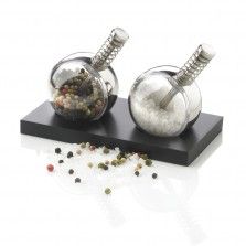 two salt and pepper shakers sitting on top of a black stand with spices in them