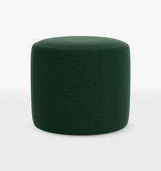 a dark green ottoman sitting on top of a white floor