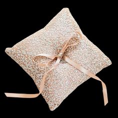 a pillow with a ribbon tied around it on top of a black background and the words,