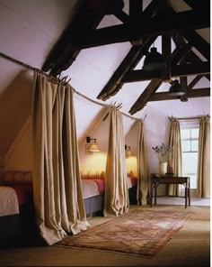 a bedroom with two beds and curtains hanging from the ceiling