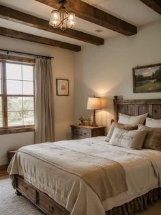 a large bed sitting under a window in a bedroom next to a dresser and lamp